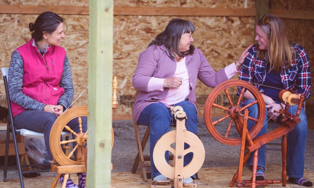 A group spinning yarn at spinning wheels