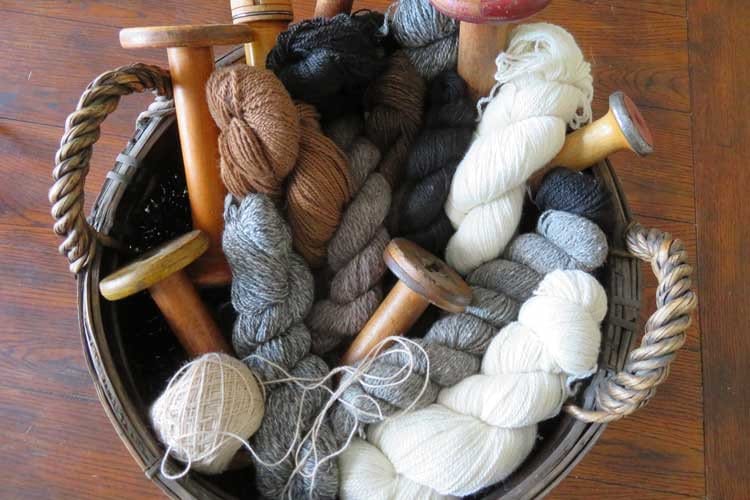 A basket filled with skeins of handmade yarn